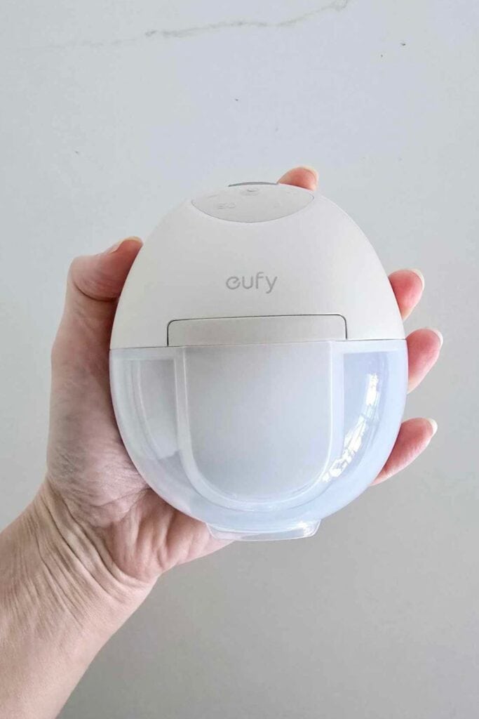 Eufy S1 Pro breast pump held in hand, showcasing its compact size and modern all-in-one design