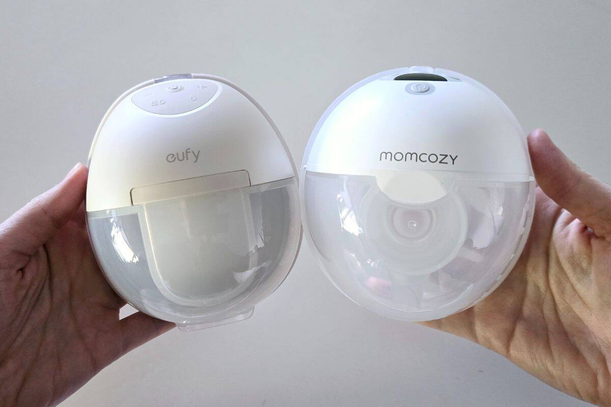 Side-by-side comparison of the Eufy S1 Pro and Momcozy M5 wearable breast pumps held in hand, showing the difference in shape, size, and design.