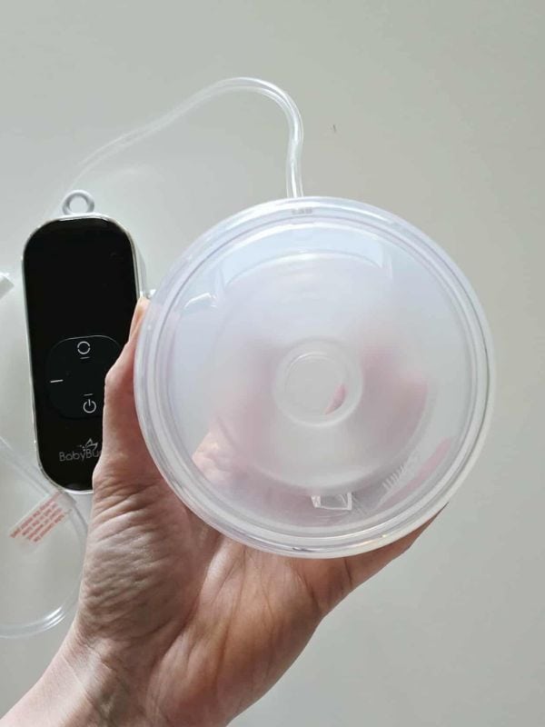 BabyBuddha 2.0 hands-free collection cup with motor hub in the background, lightweight closed system design for portable pumping.