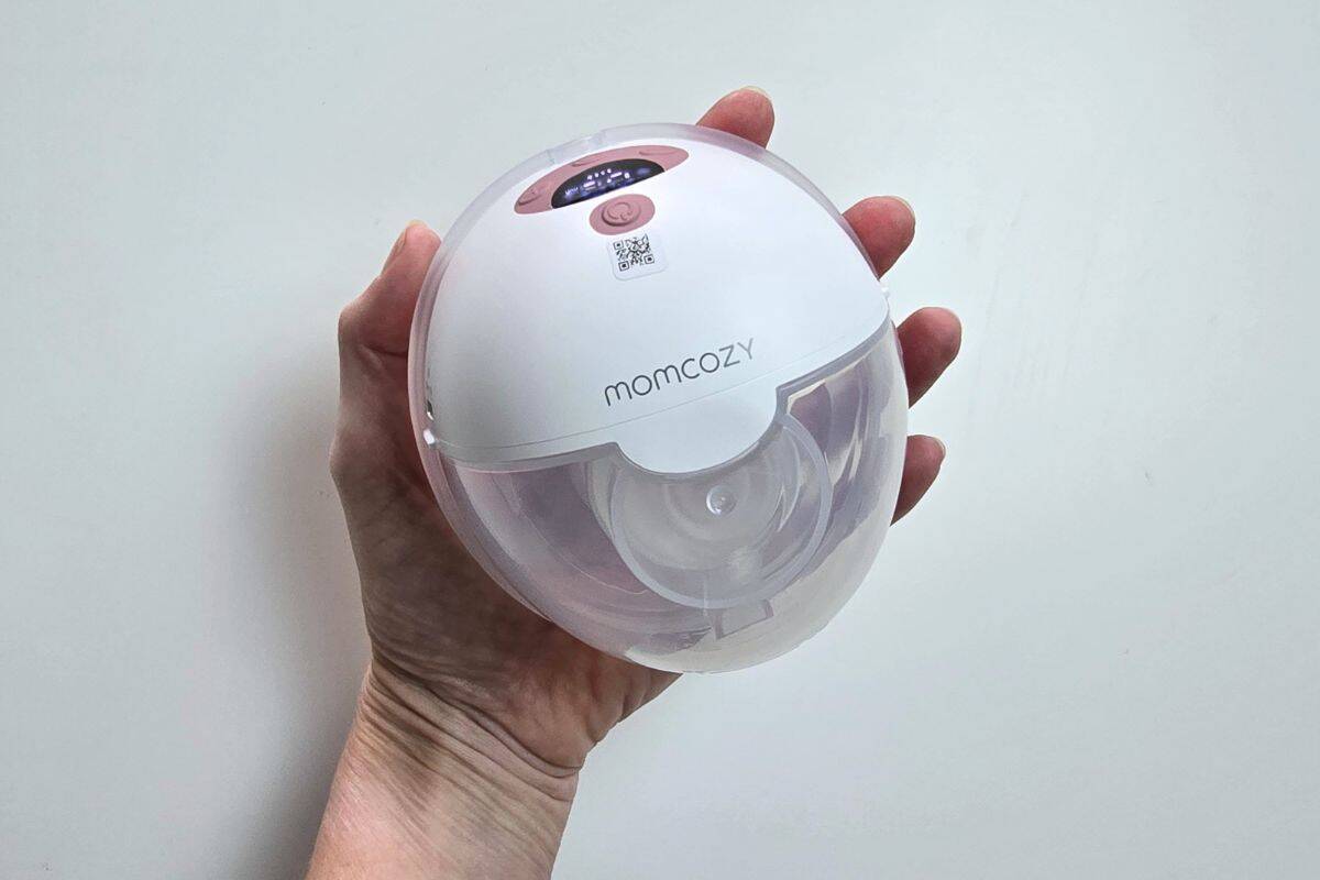 Momcozy M5 Smart wearable breast pump held in hand showing compact design